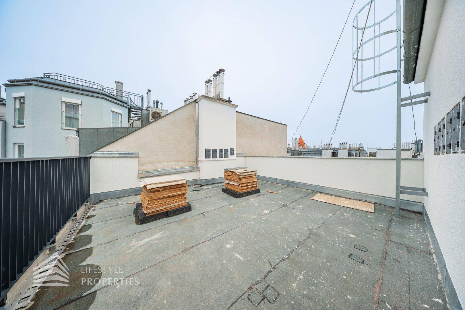 Große Dachterrasse mit Blick auf die Dächer der Stadt, bereit für die Gestaltung.