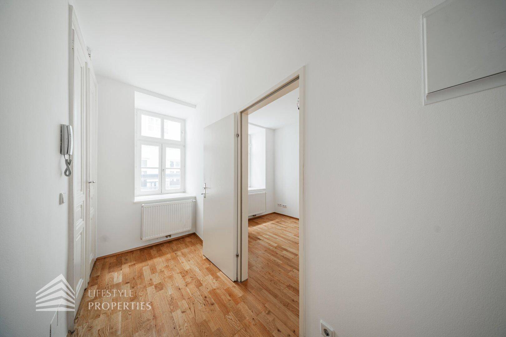 Heller Flur mit Parkettboden und Zugang zu weiteren Zimmern, inklusive Gegensprechanlage.