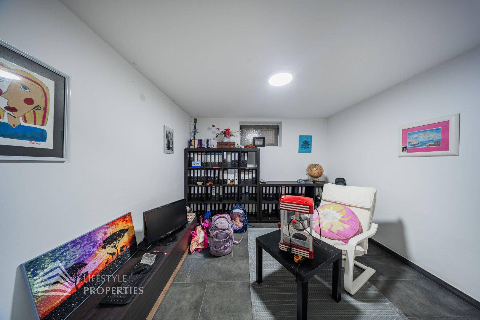 Vielseitiger Raum im Untergeschoss, eingerichtet als Büro oder Hobbyzimmer.