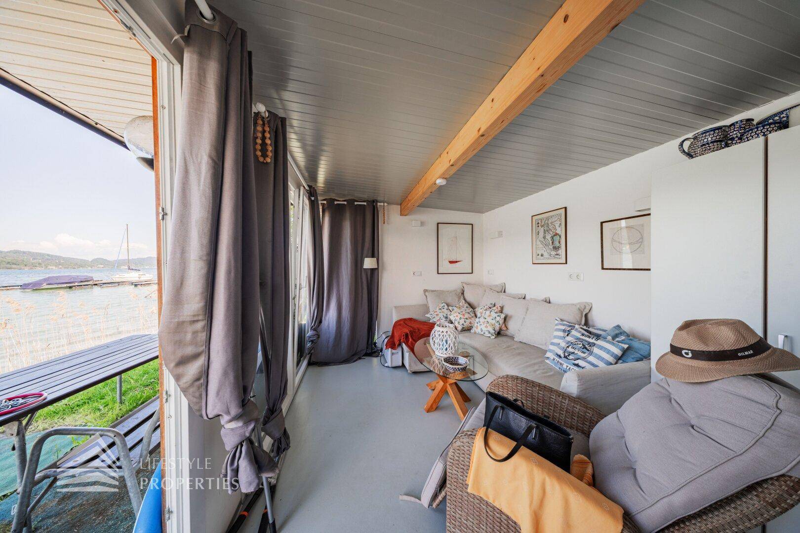 Heller Wohnbereich mit Seeblick, bequemen Sofas und Zugang zu einem Außenbereich.