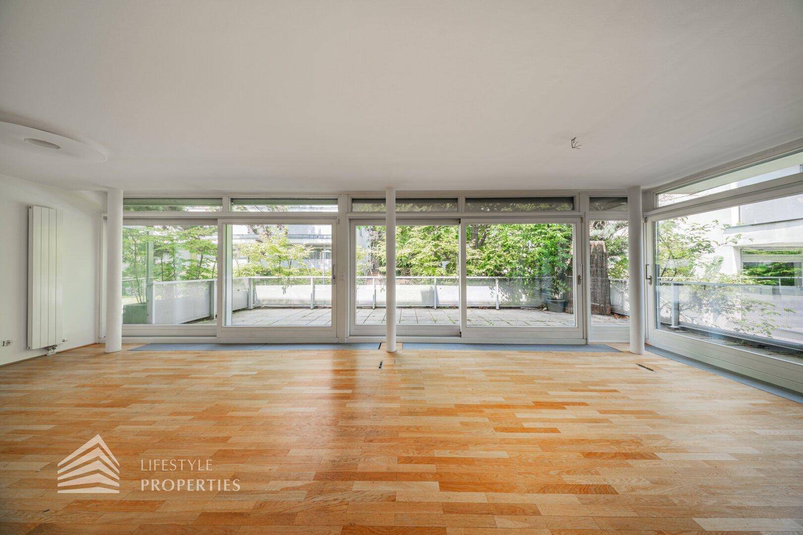 Geräumiges Wohnzimmer mit viel Tageslicht und direktem Zugang zur großen Terrasse.