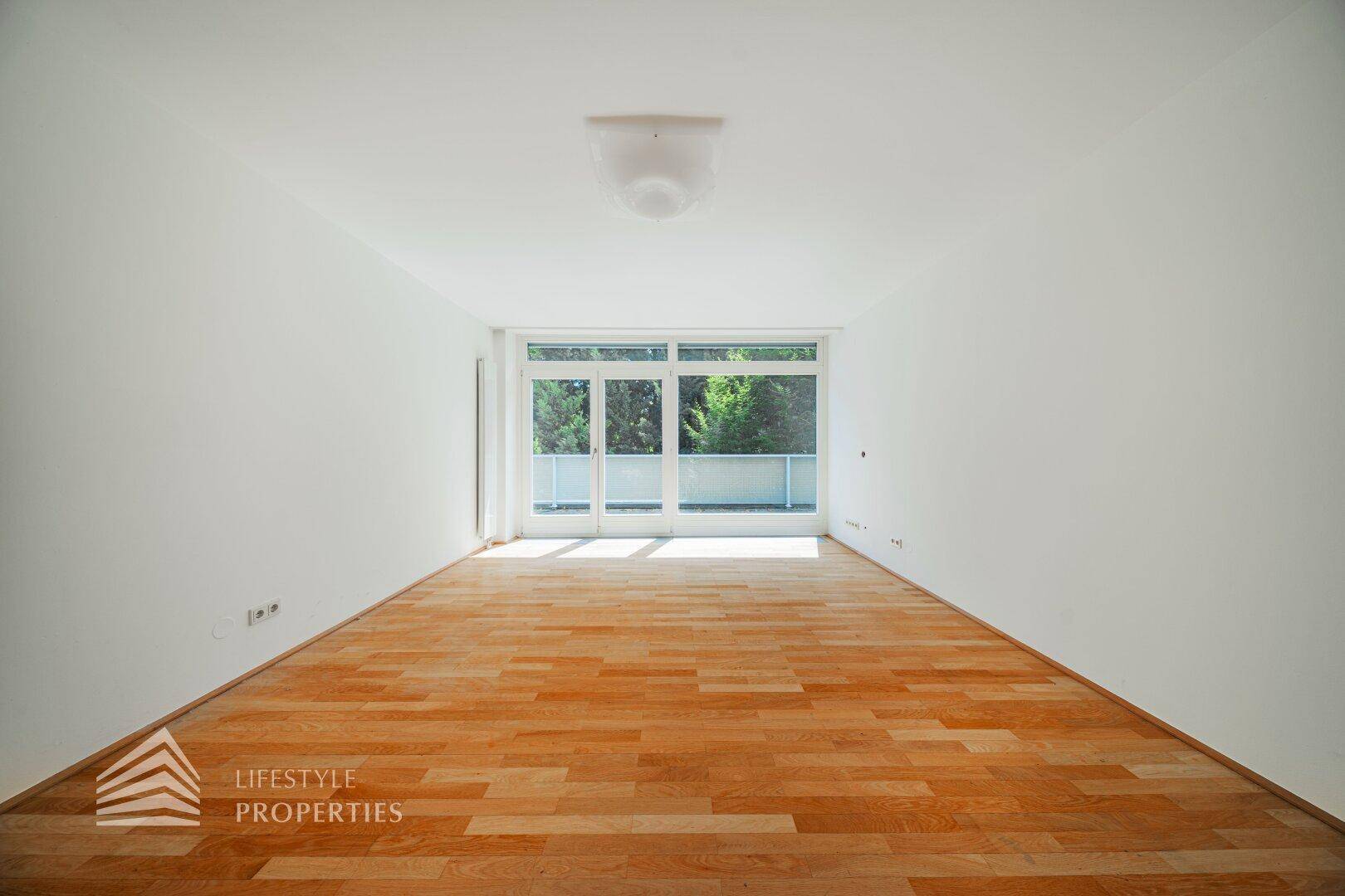 Helles Schlafzimmer mit Holzboden und großzügigem Zugang zu einem Außenbereich.