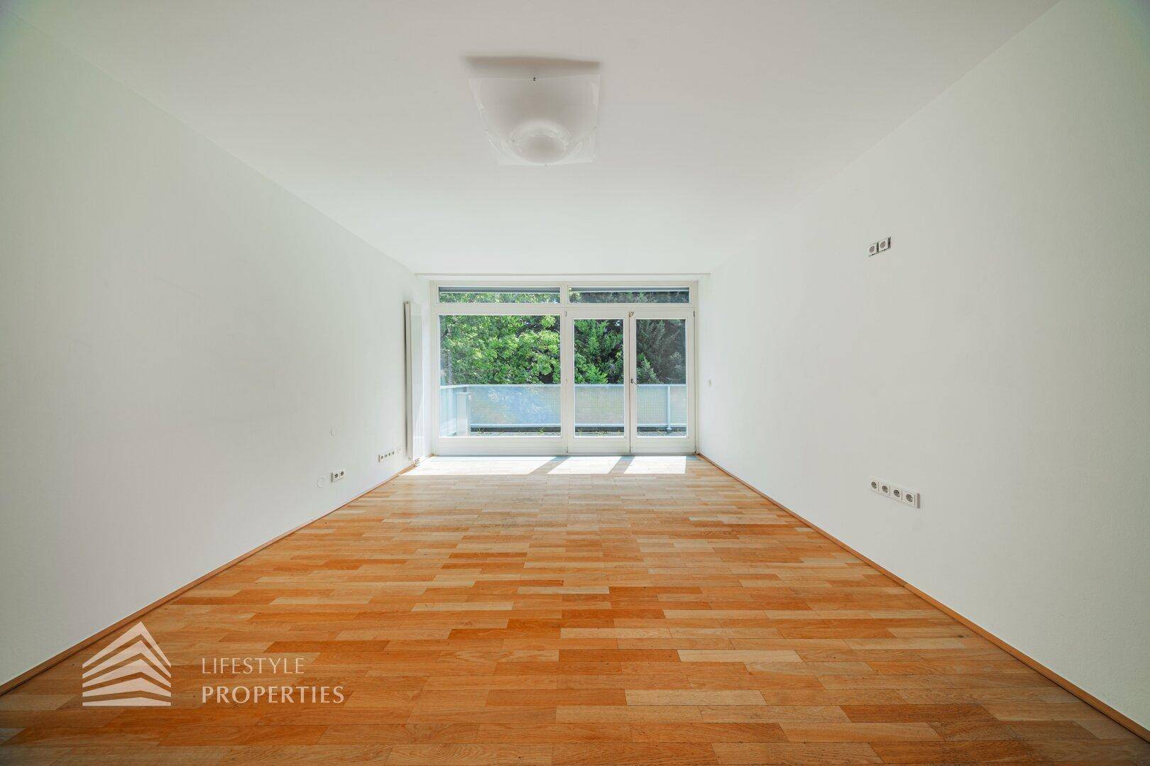 Helles Schlafzimmer mit Holzboden und großzügigem Zugang zu einem Außenbereich.