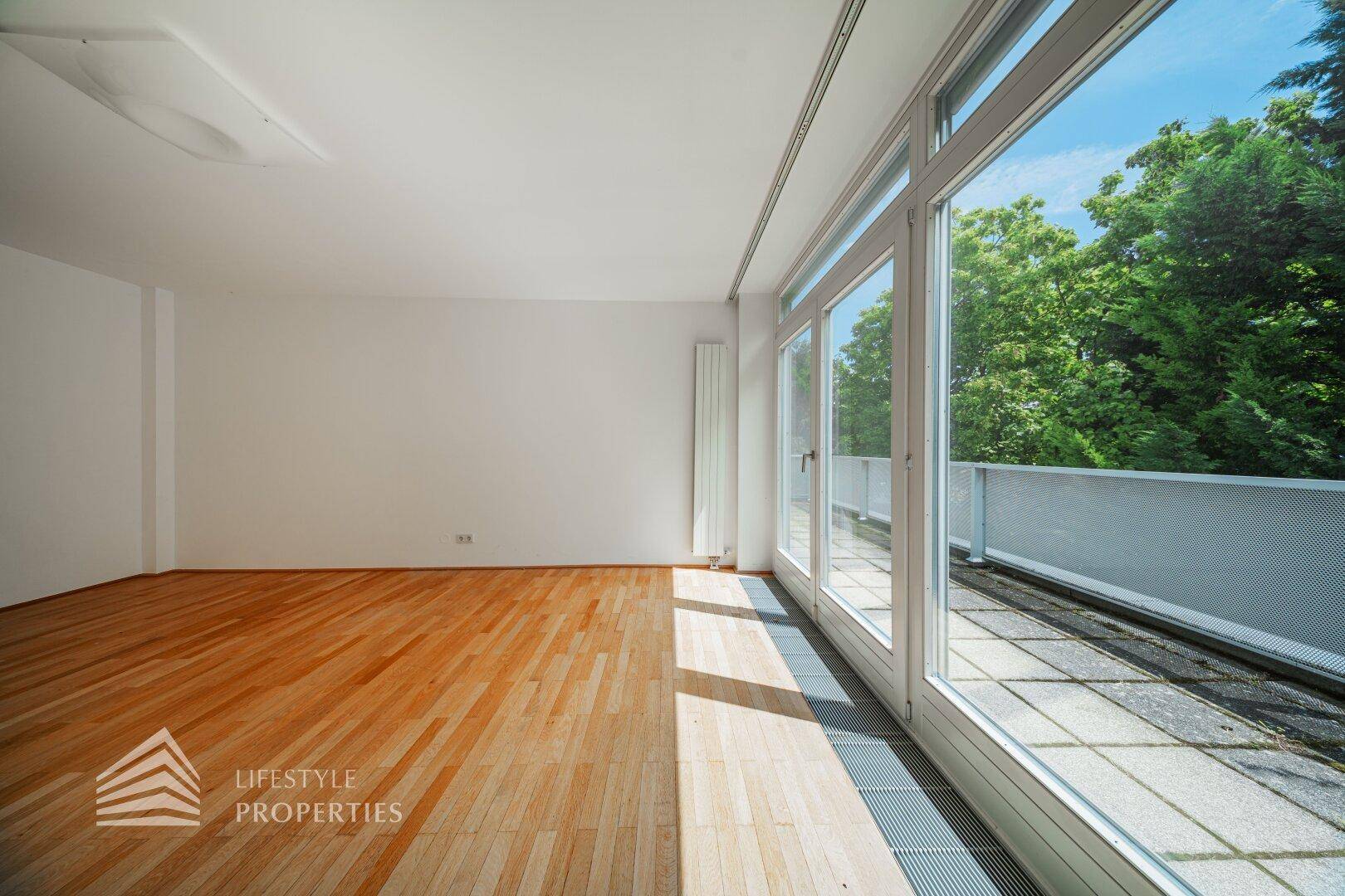 Geräumiges Schlafzimmer mit Holzboden und direktem Zugang zur sonnigen Terrasse.