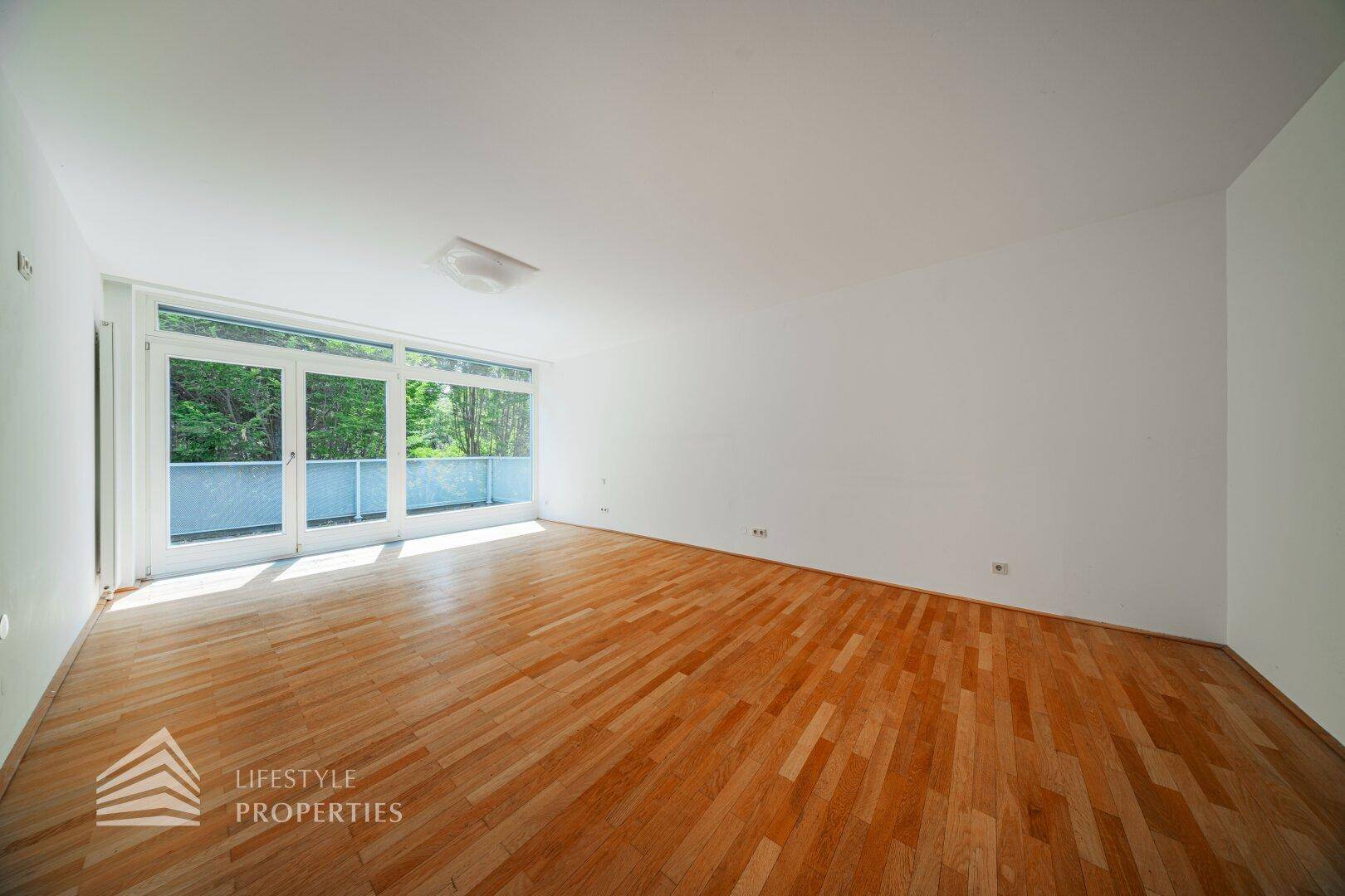 Geräumiges Schlafzimmer mit Holzboden und direktem Zugang zu einem sonnigen Außenbereich.