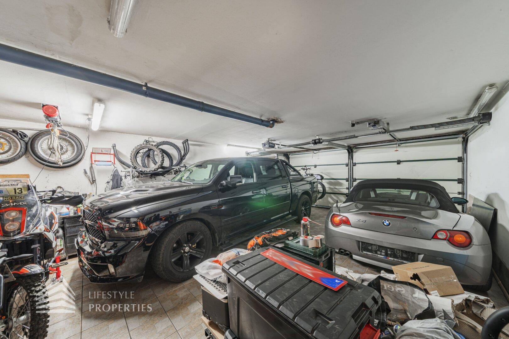 Gut organisierte Garage mit zwei Autos, Werkzeugen und zusätzlichen Lagerflächen.