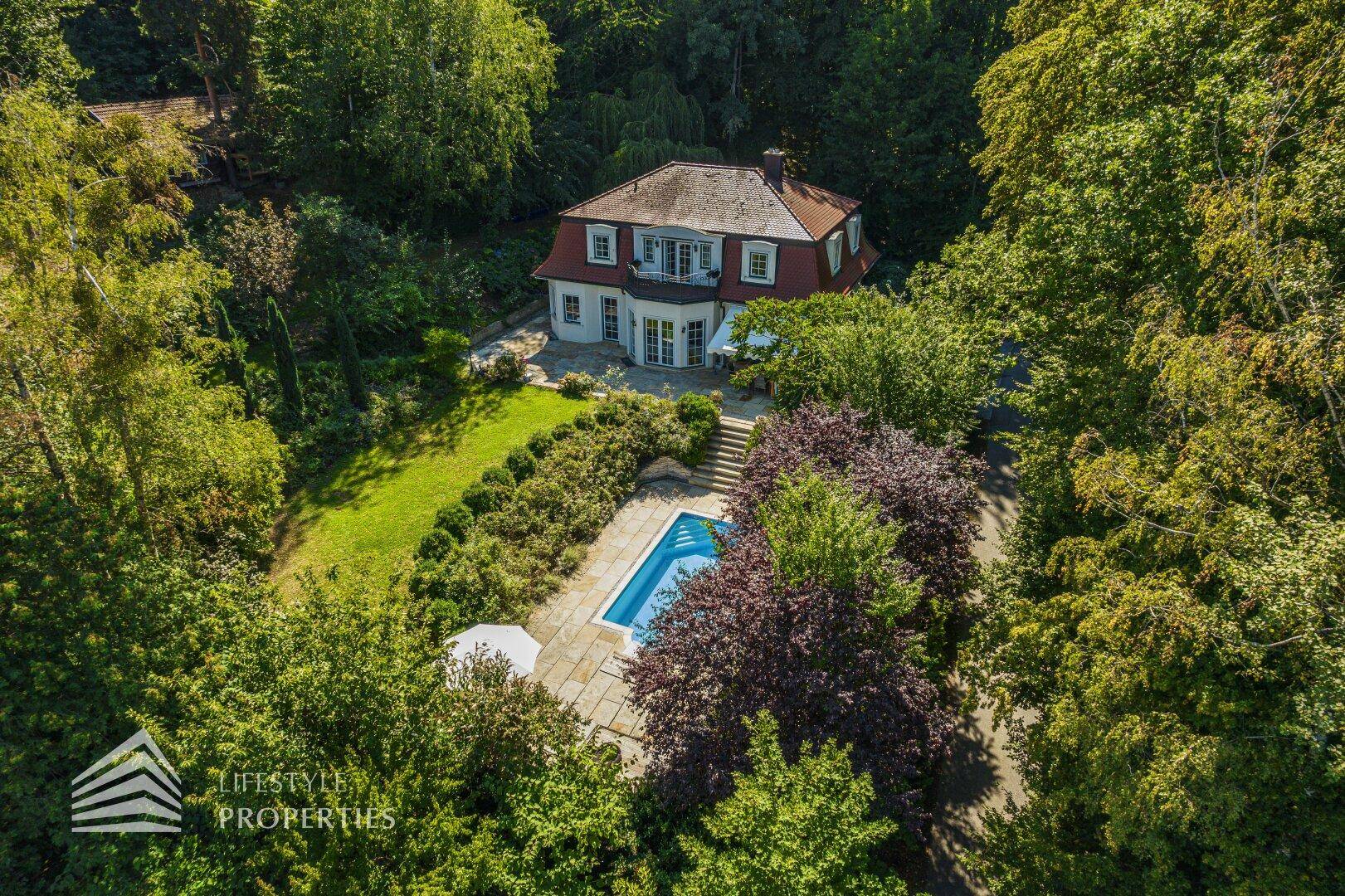 Luftaufnahme des Anwesens mit großem Garten, privatem Pool und umgebender Natur.