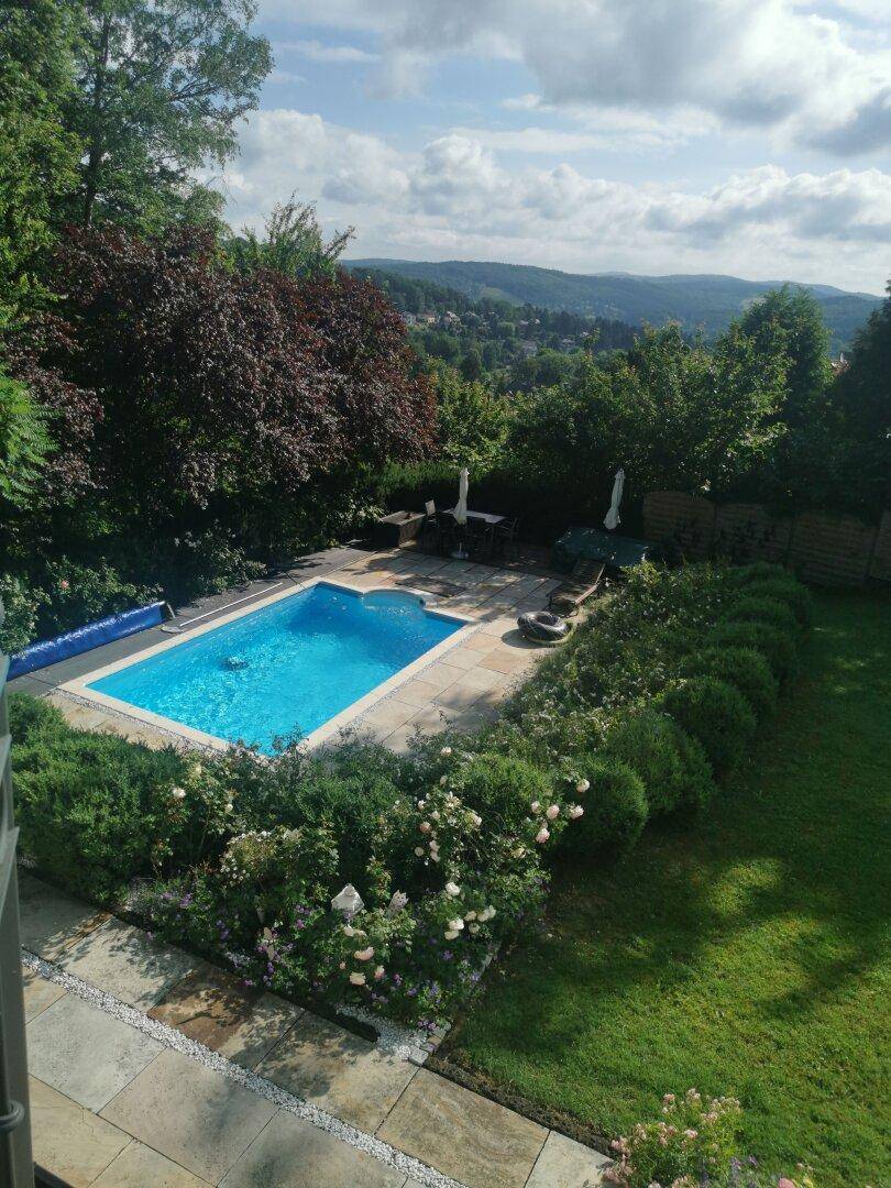 Gartenbereich mit Pool und weitem Blick über die hügelige Landschaft.