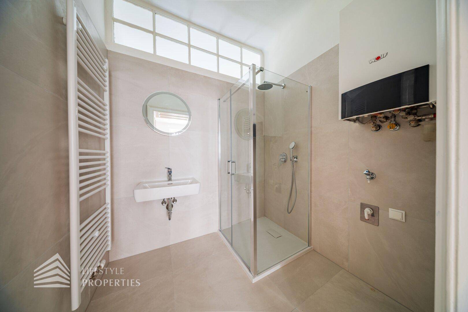 Modernes Badezimmer mit begehbarer Dusche, Wandwaschbecken und beheiztem Handtuchhalter.