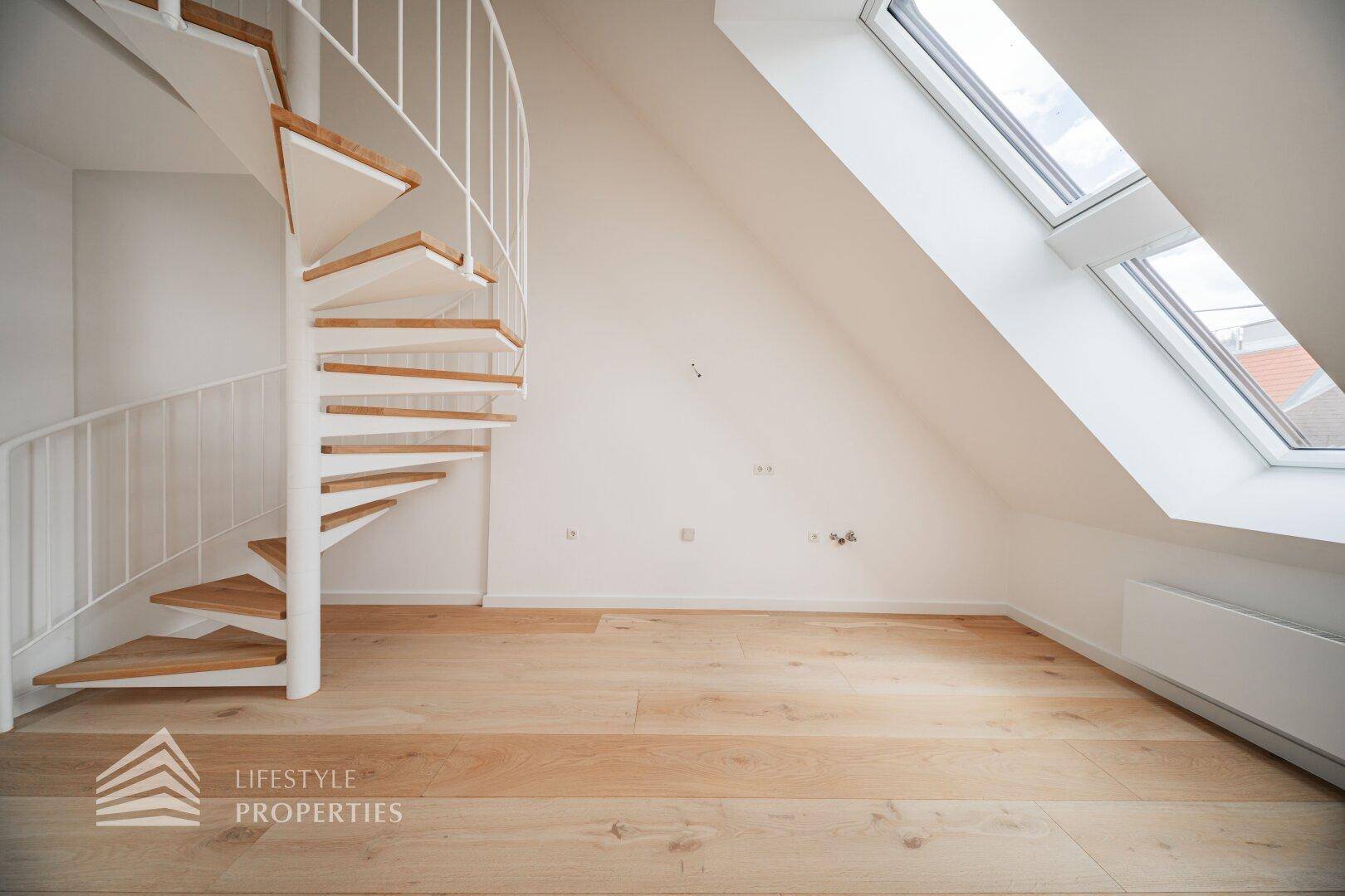 Detailansicht der modernen Wendeltreppe und des großen Dachfensters im hellen Dachgeschossraum.