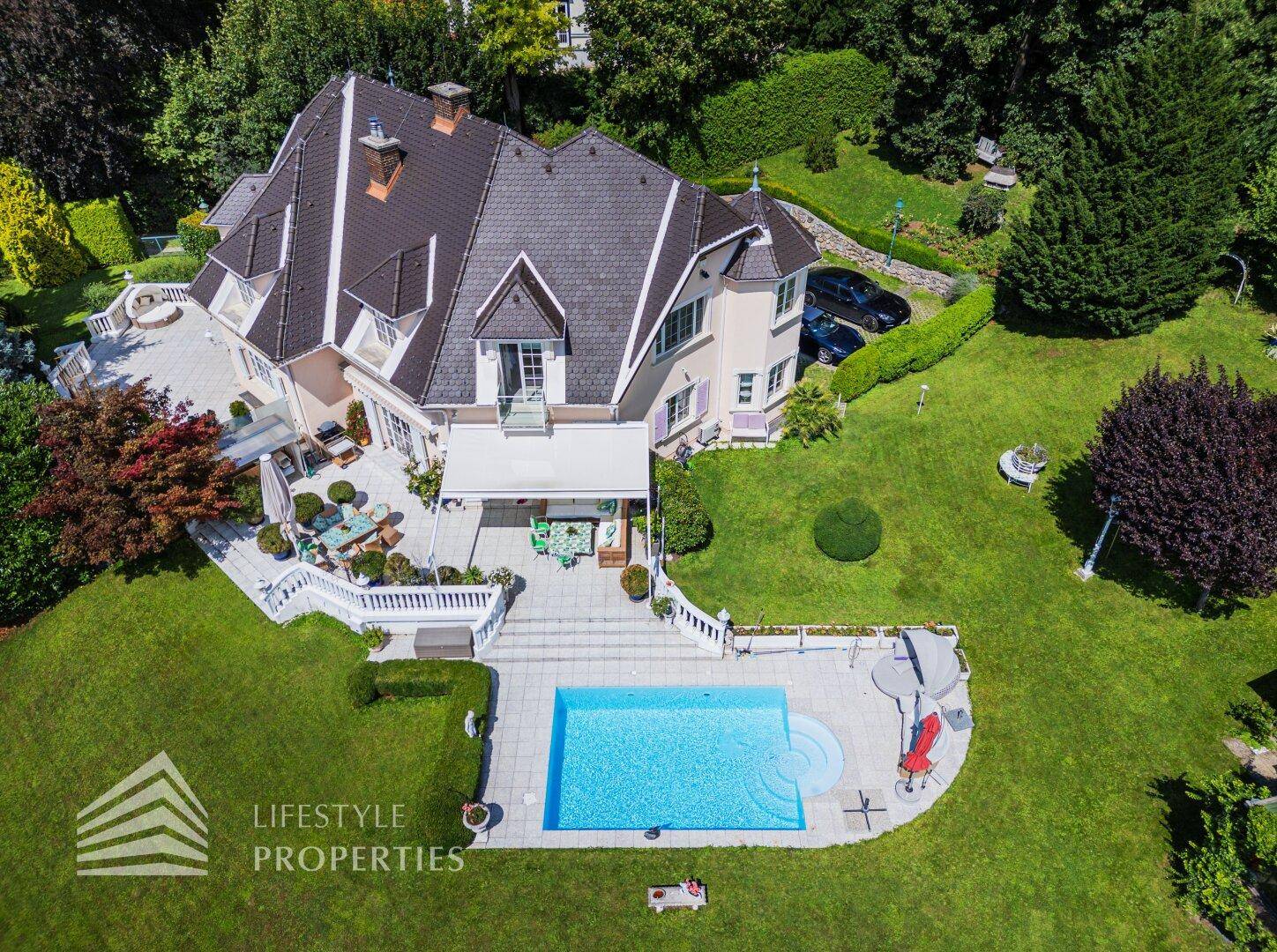 Vogelperspektive der Villa mit Pool, großzügiger Terrasse und gepflegtem Gartenbereich.
