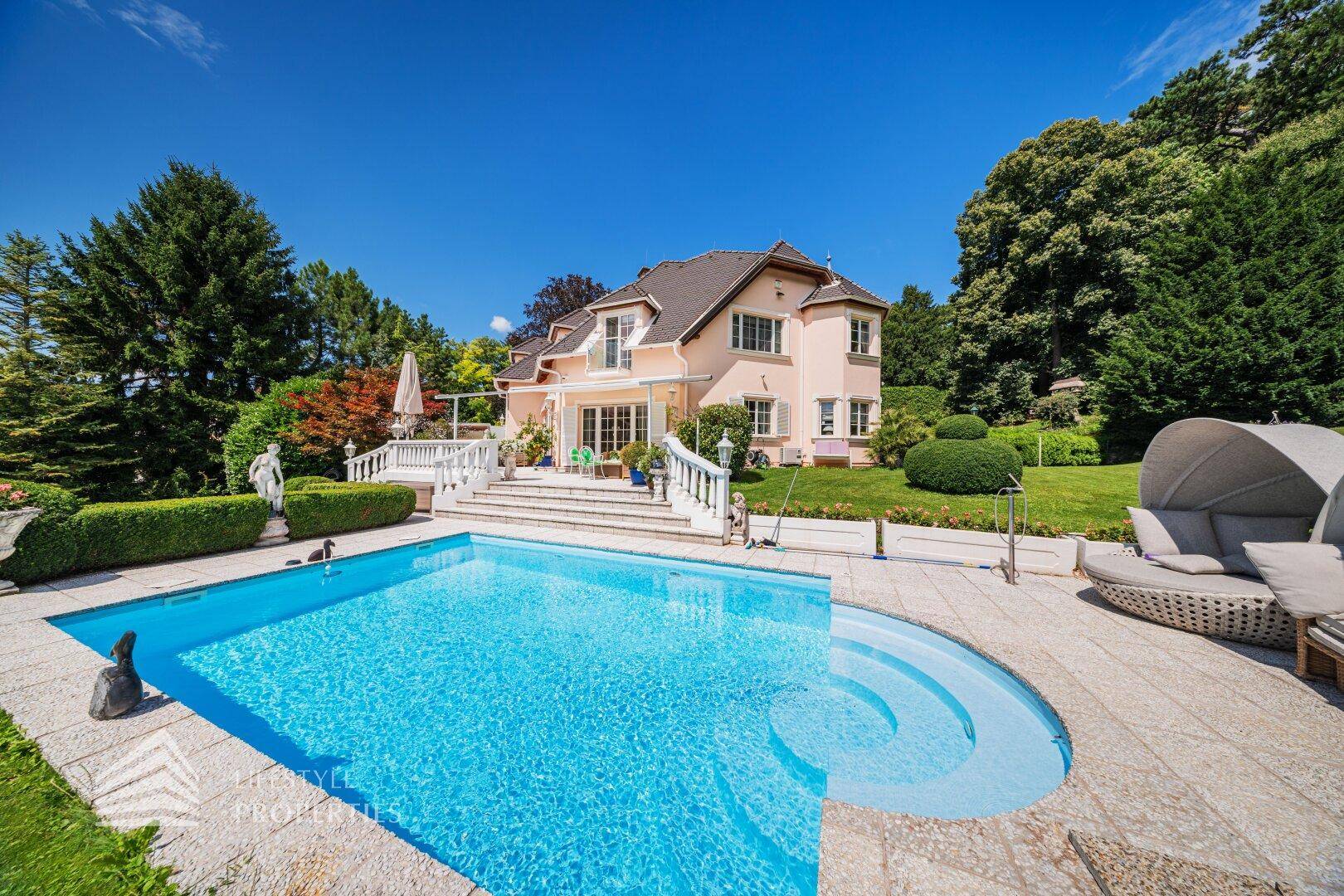 Der großzügige Poolbereich mit Sonnenterrasse und bequemen Liegemöbeln vor der Villa.