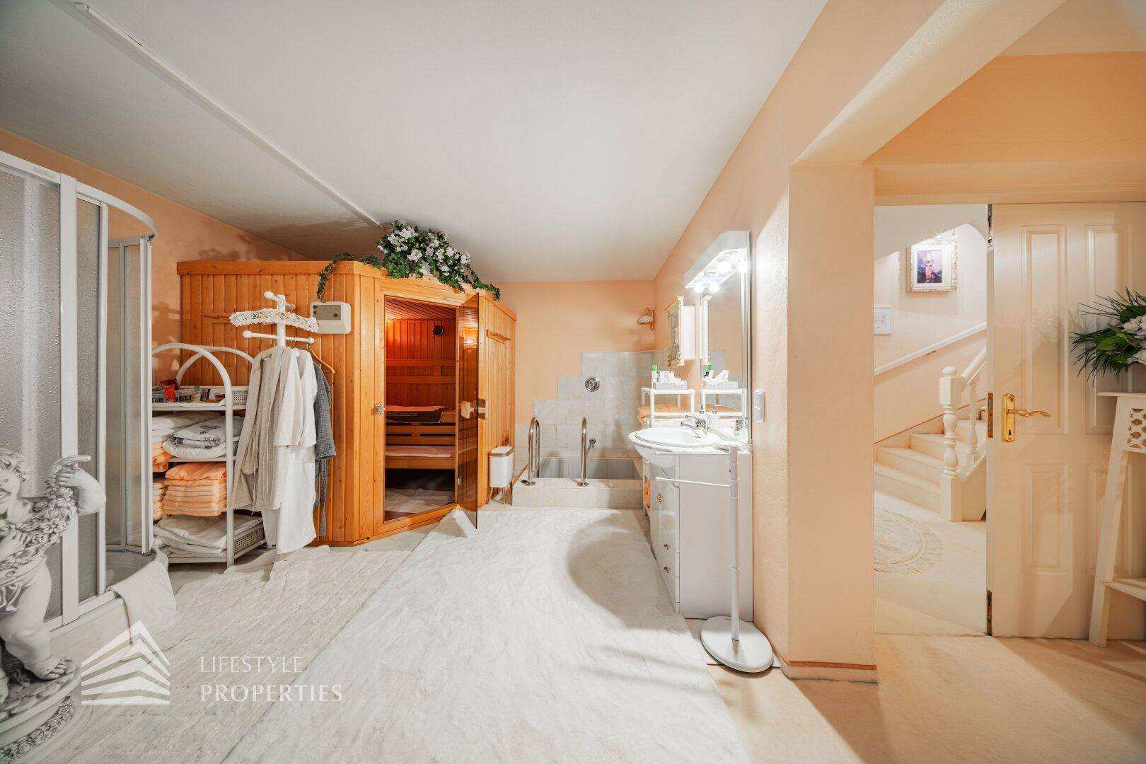 Wellnessbereich mit Sauna, Dusche und Waschbecken, ideal zur Entspannung und Erholung.