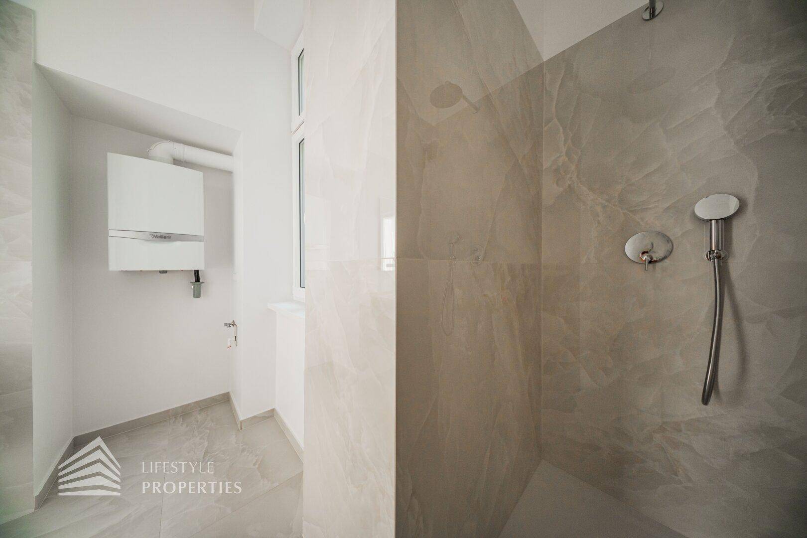 Moderne Dusche mit großformatigen Fliesen und separatem Bereich für die Gastherme.