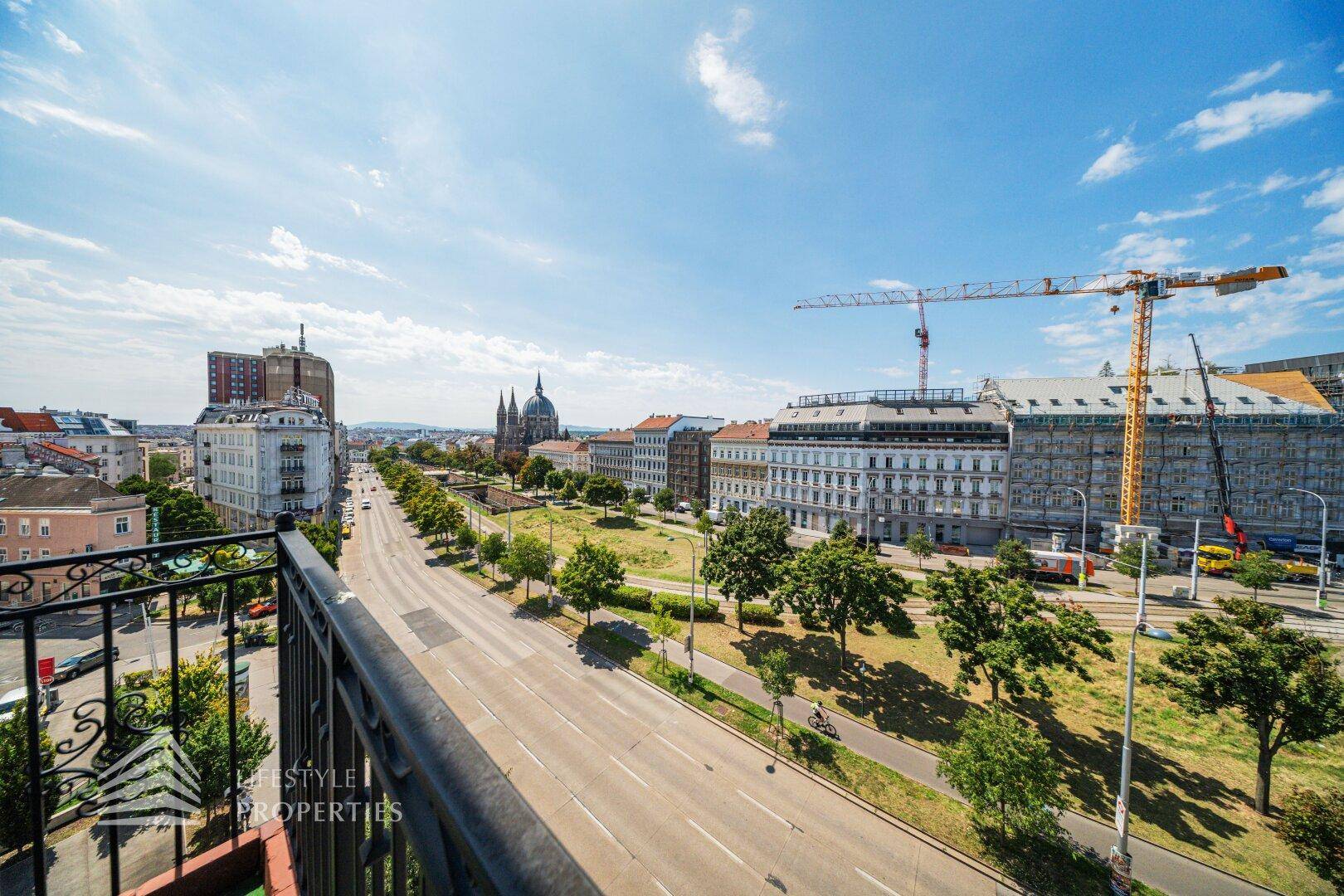Panoramablick vom Balkon auf die Stadtlandschaft mit historischen und modernen Gebäuden.