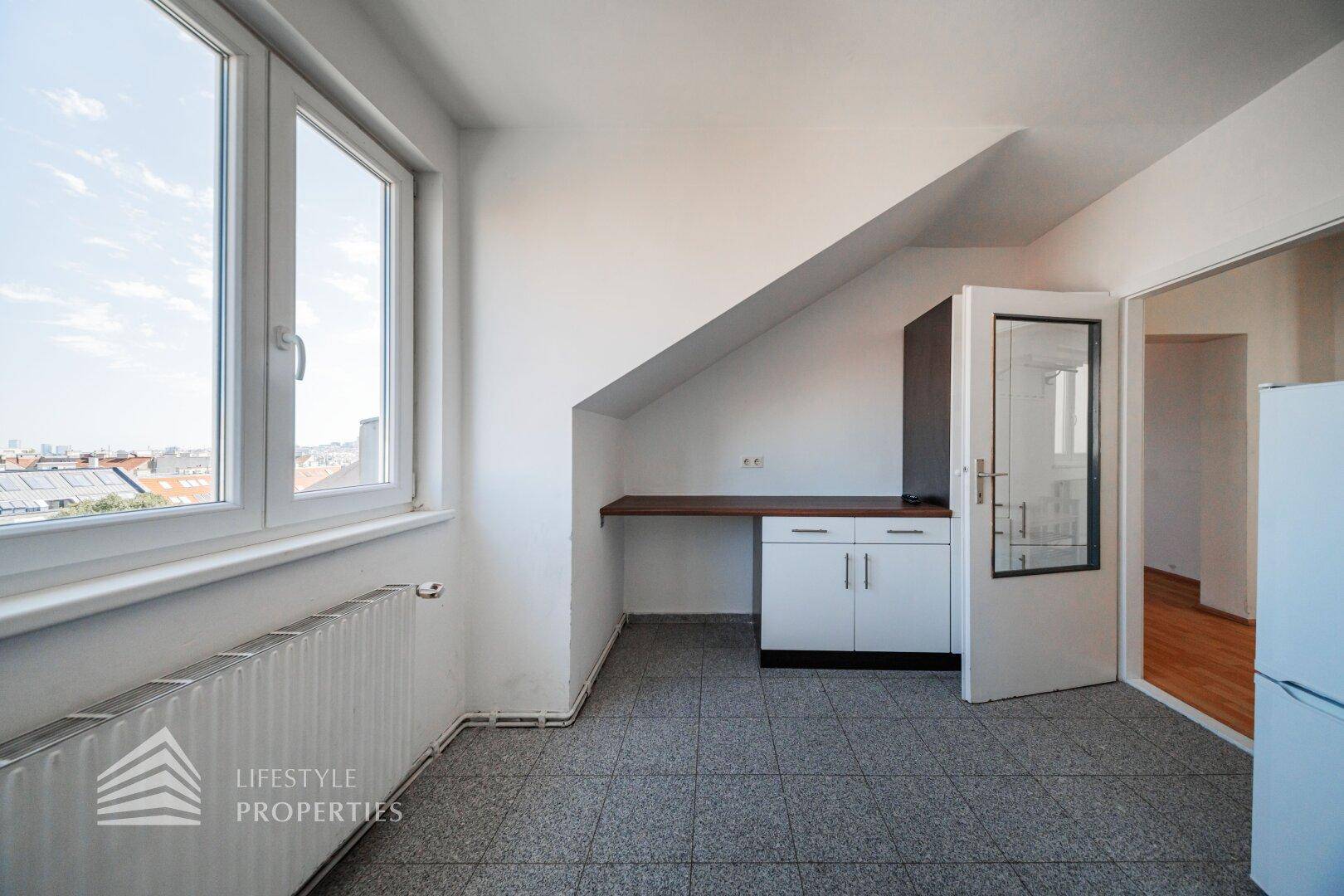 Kleiner Küchenbereich oder Arbeitsplatz mit Fenster und Blick über die Stadt.