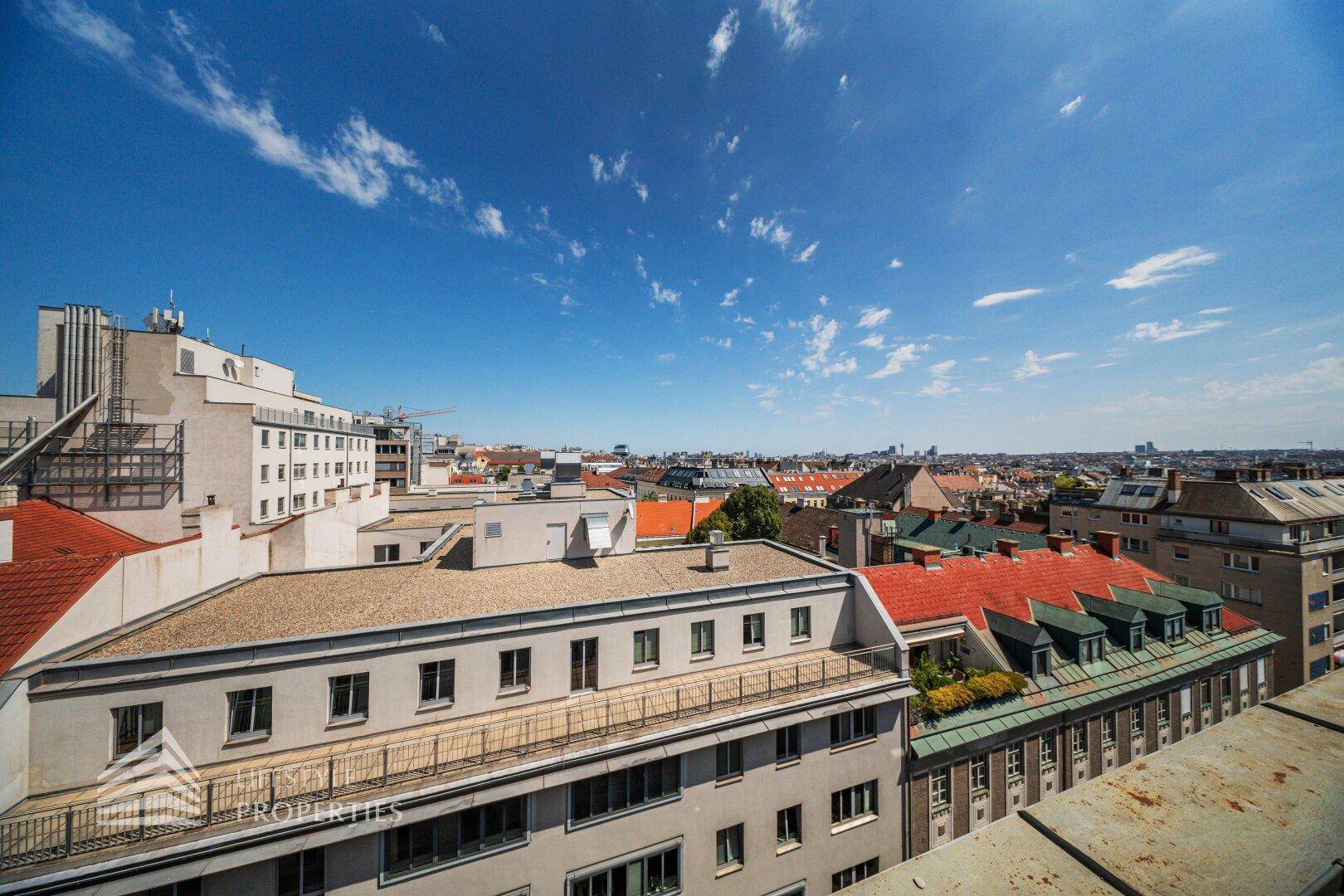 Weitläufiger Blick über die Dächer der Stadt an einem sonnigen Tag.