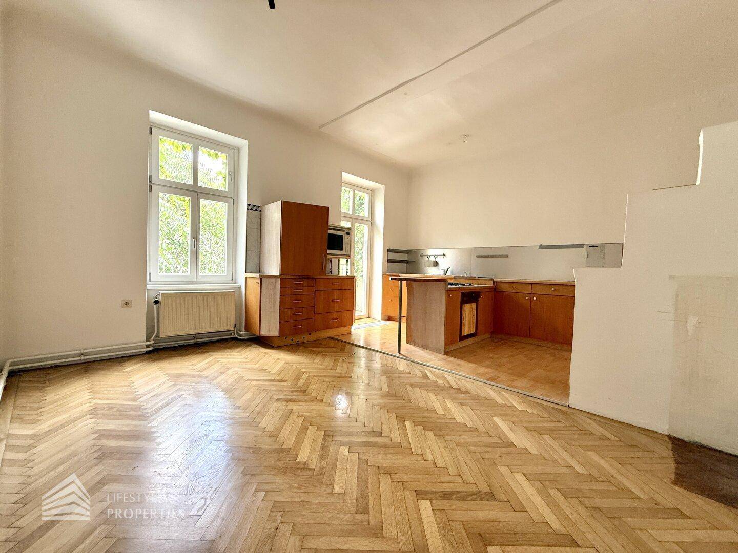 Helle Küche mit Fischgrätparkett und Holzschränken, bietet Potenzial für eine moderne Umgestaltung.