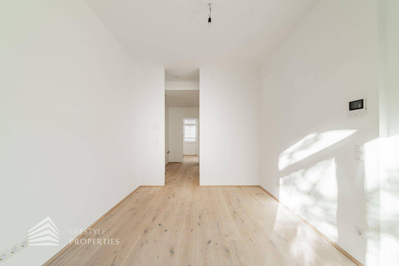 Geräumiger, heller Raum mit Holzboden und weißen Wänden, bereit zur individuellen Gestaltung.