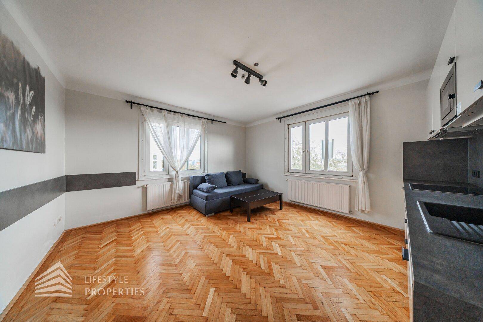 Gemütlicher Wohnbereich mit Sofa, Couchtisch und Blick auf die Umgebung durch die Fenster.