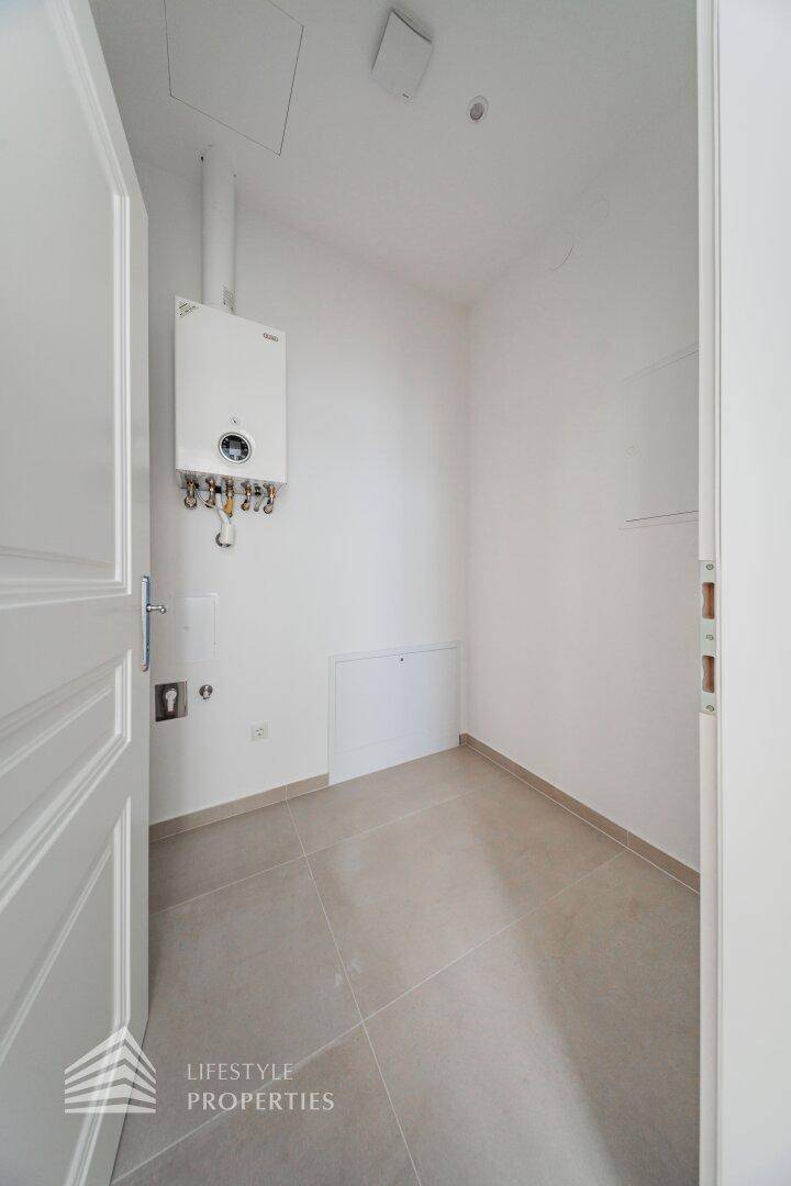 Praktischer Hauswirtschaftsraum mit Fliesenboden und Wandheizung, ideal für Technik und Lagerung.