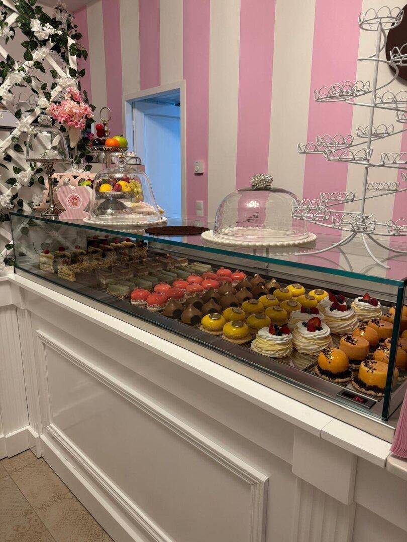 Nahaufnahme einer gut gefüllten Verkaufstheke mit verschiedenen Gebäckstücken und Desserts, appetitlich präsentiert.