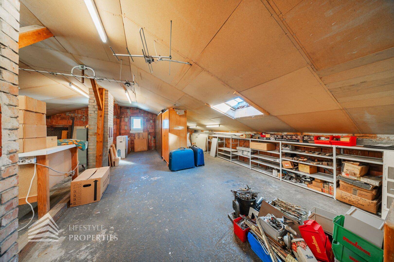 Geräumiger Dachboden mit Holzbalken, Dachfenster und viel Stauraum.