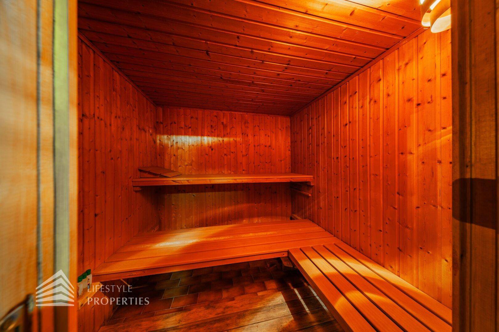 Holzvertäfelte Sauna mit Sitzbänken, ideal zur Entspannung und Erholung.