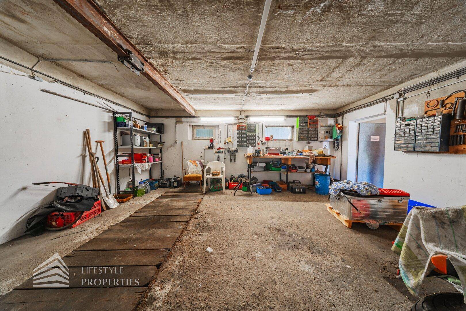 Garage mit Werkbank, Regalen und viel Stauraum für Hobby und Arbeit.