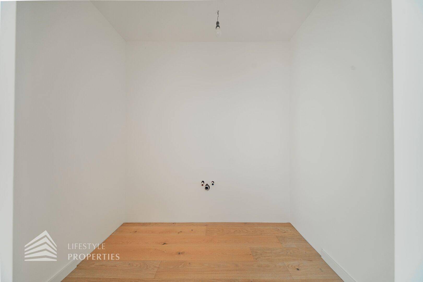 Kleiner Raum mit Anschlüssen, ideal als Abstellraum oder für eine Waschküche.