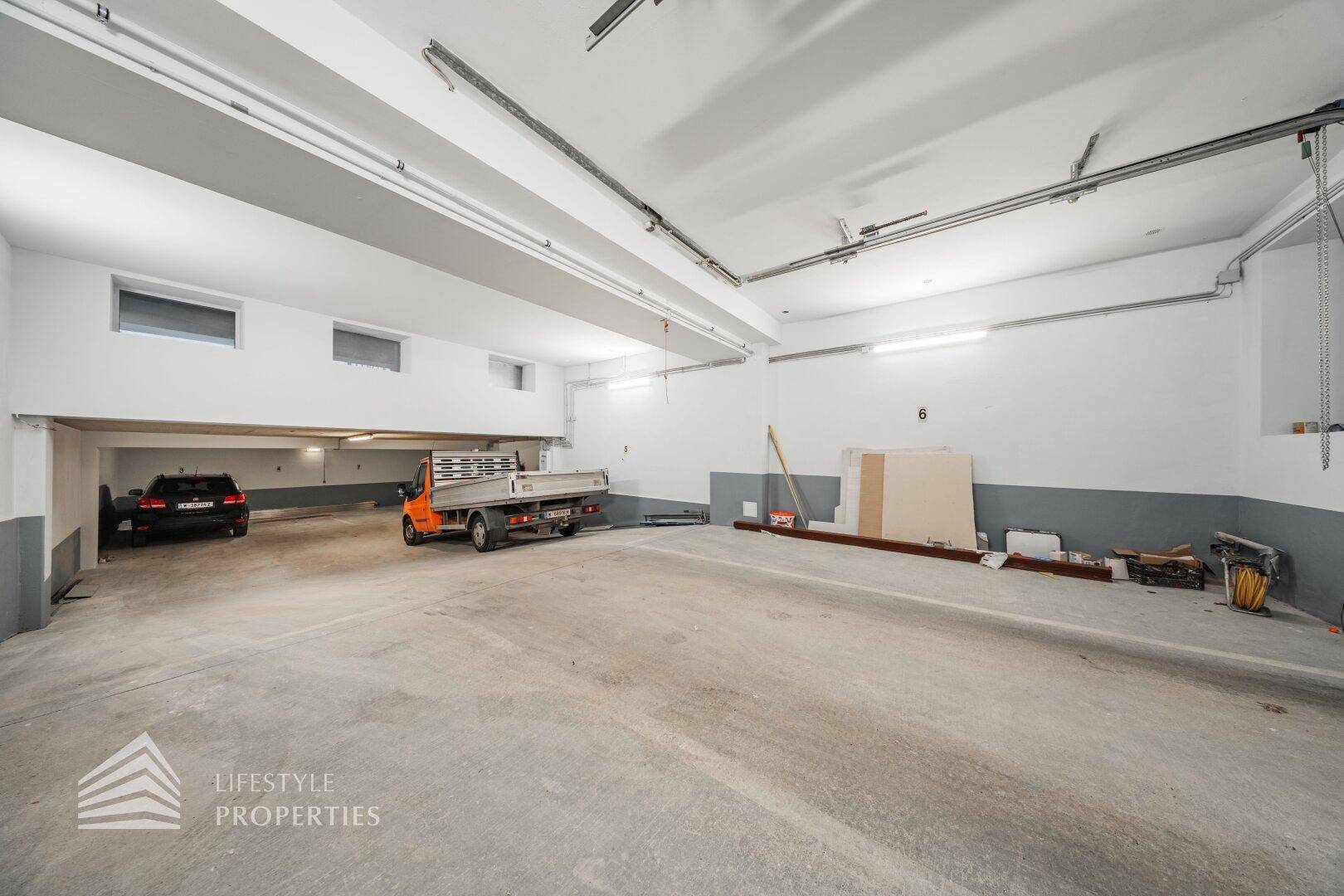 Weitläufige Tiefgarage mit mehreren Stellplätzen und Zufahrt für verschiedene Fahrzeuge.