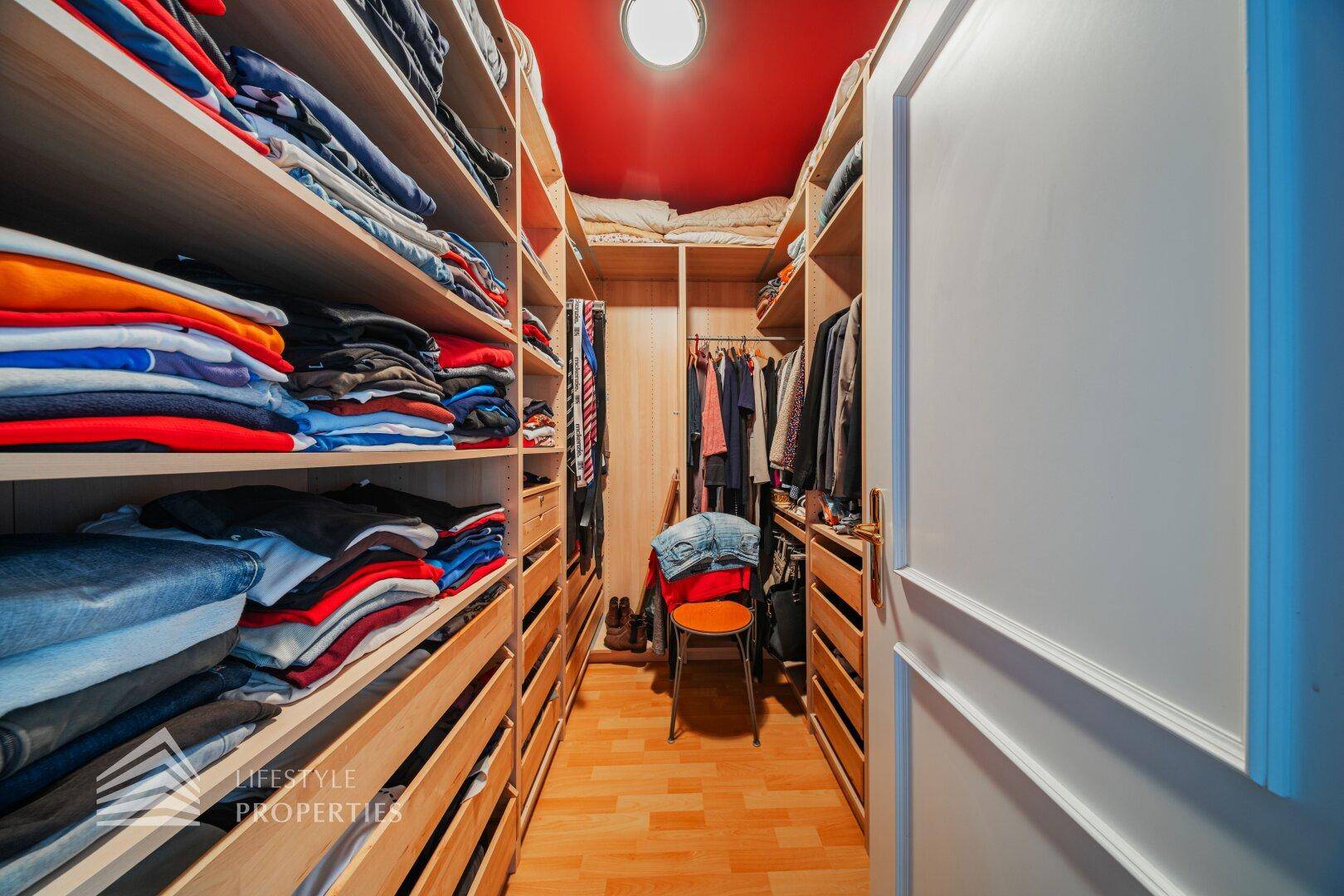 Begehbarer Kleiderschrank mit vielen Regalen und Stauraum für Kleidung und Accessoires.