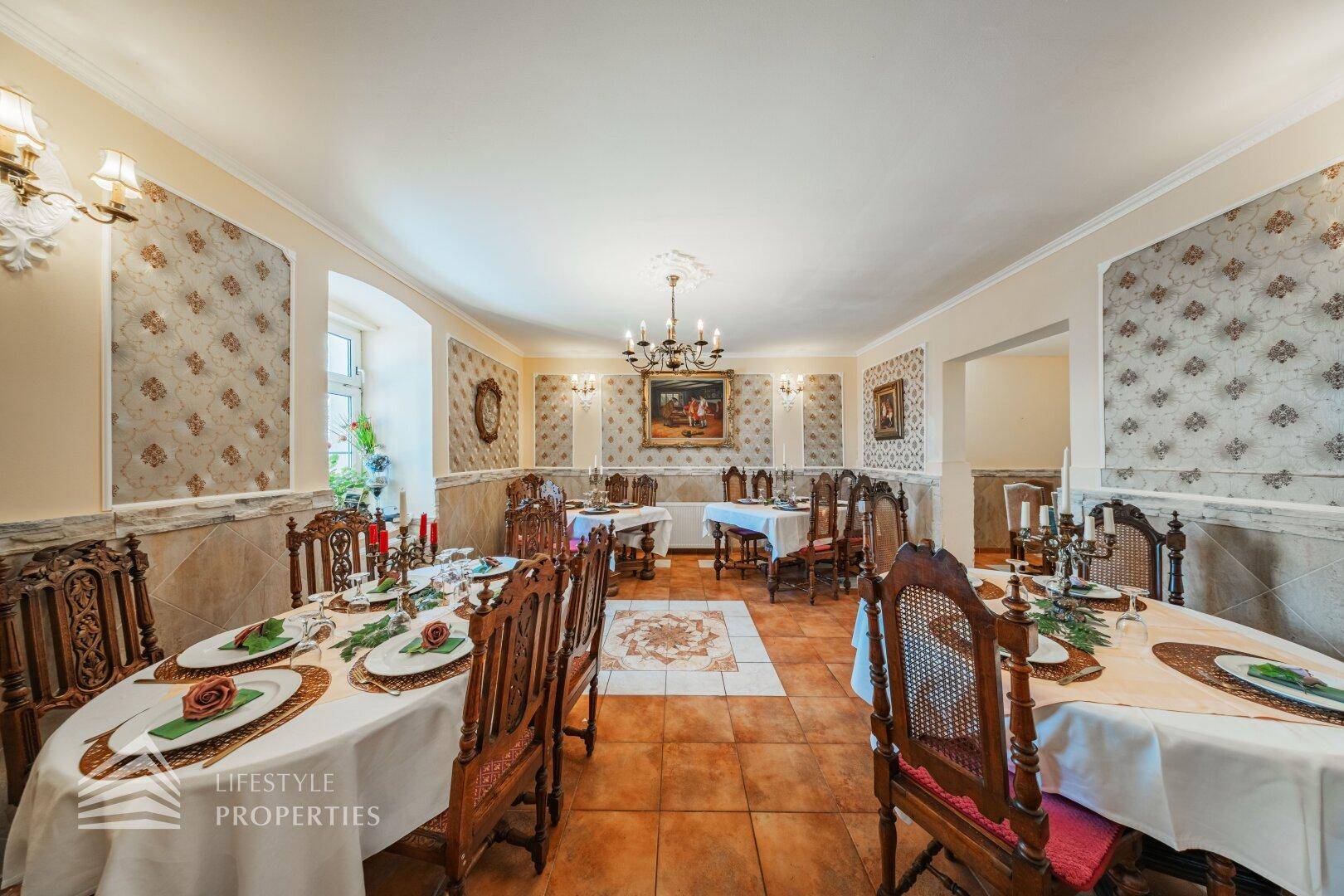 Weiterer Blick in den eleganten Speisesaal mit festlich gedeckten Tischen und klassischem Ambiente.