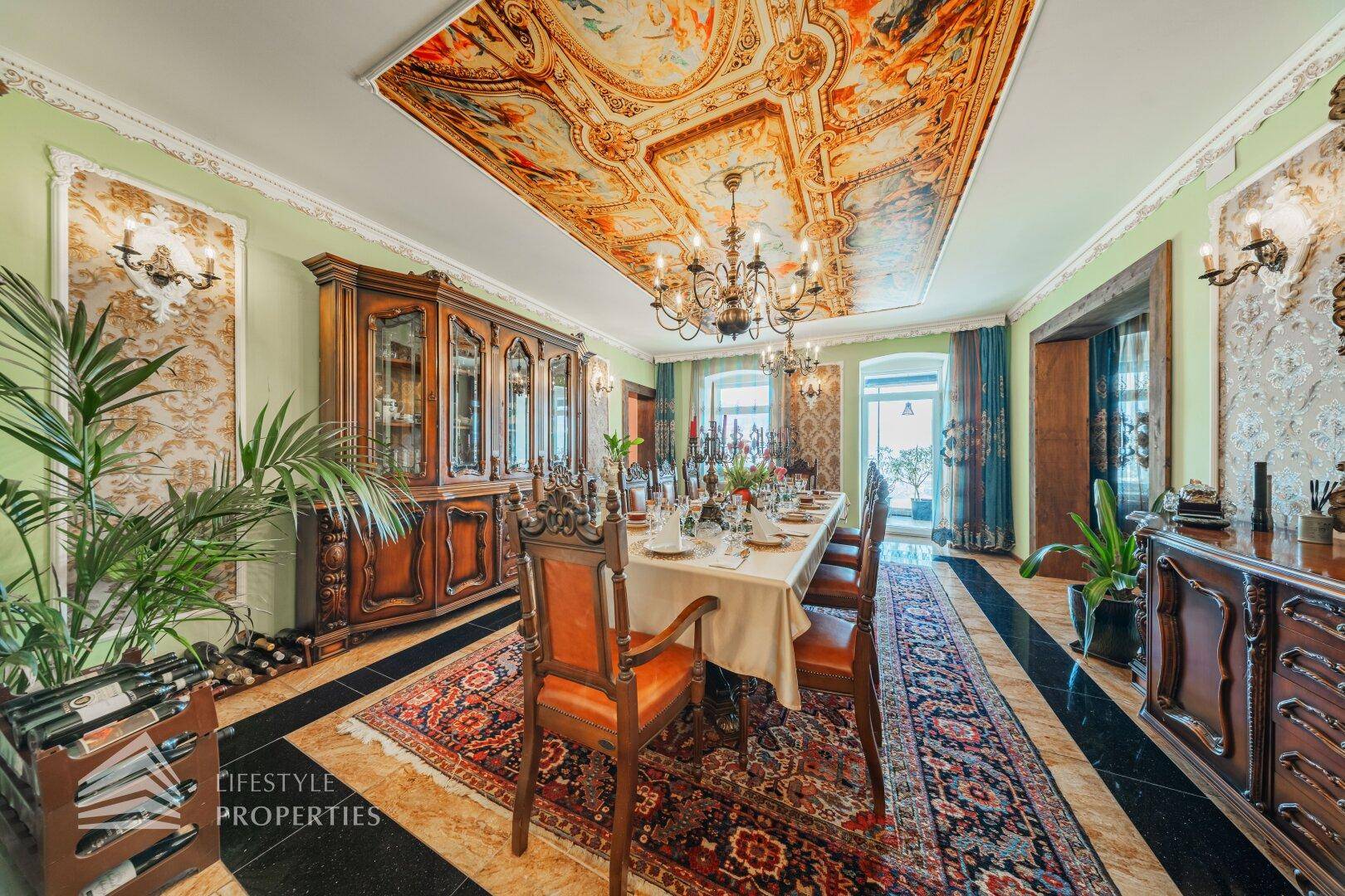 Eleganter Speisesaal mit antiken Holzschränken, Pflanzen und dem kunstvollen Deckengemälde.