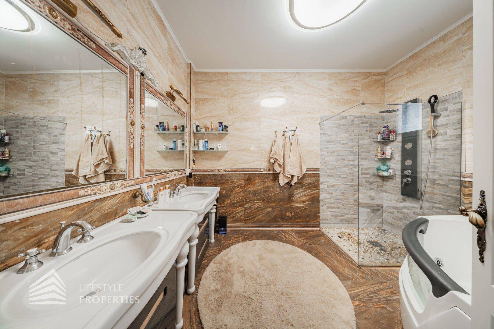 Großes Badezimmer mit Doppelwaschbecken, begehbarer Dusche und Eckbadewanne mit Whirlpool-Funktion.