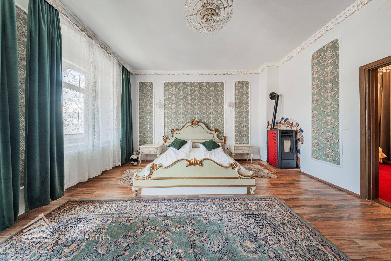 Schlafzimmer mit zwei Einzelbetten, einem modernen Ofen und einem Fenster mit Blick nach draußen.