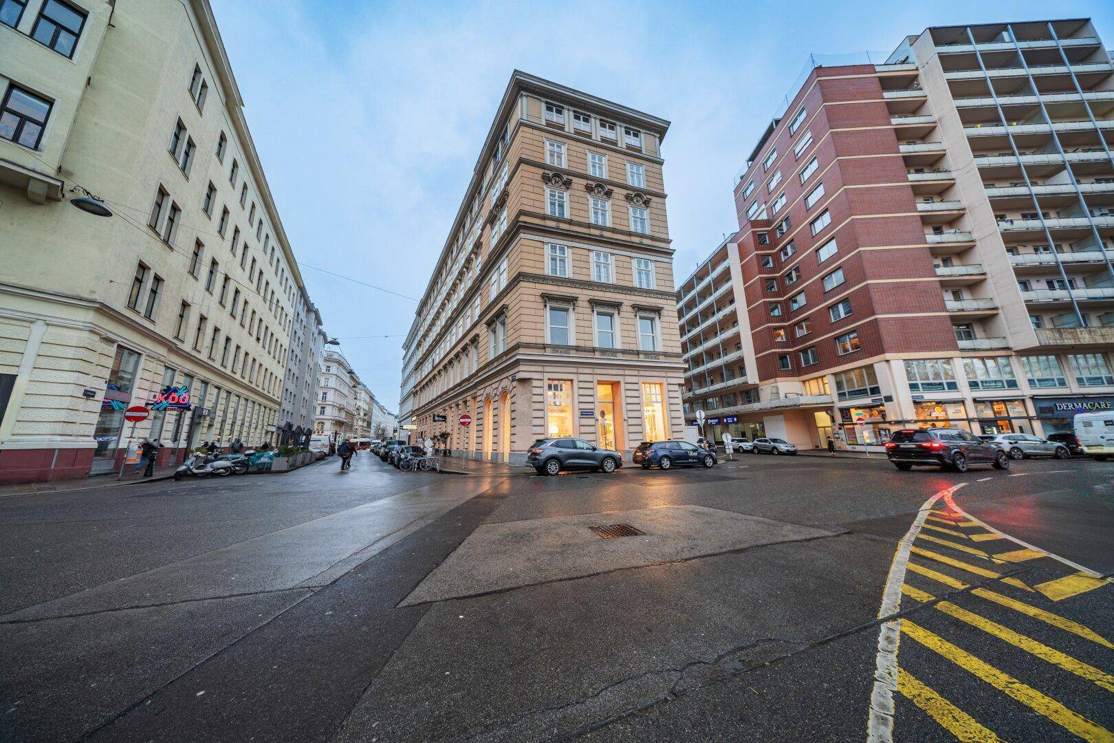 Weitläufige Stadtansicht mit mehreren Gebäuden, belebten Straßen und einem klaren Himmel.