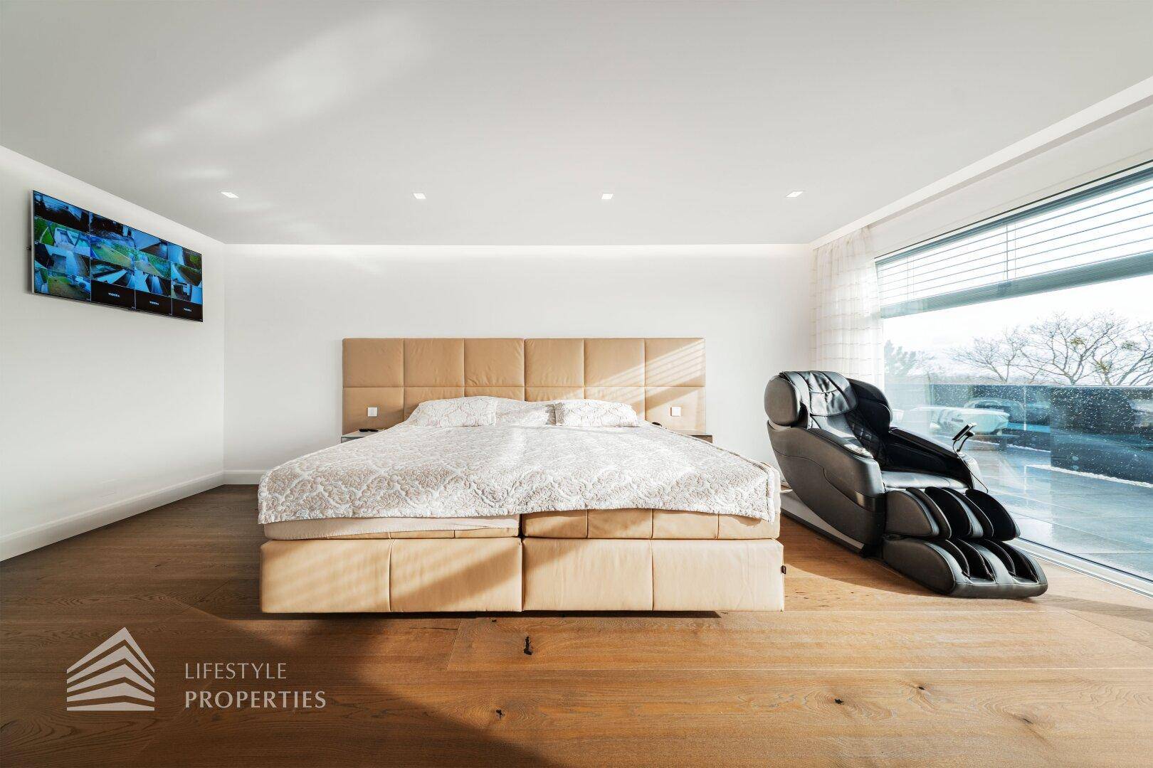 Helles Schlafzimmer im Dachgeschoss mit Doppelbett, Holzboden und viel Tageslicht.