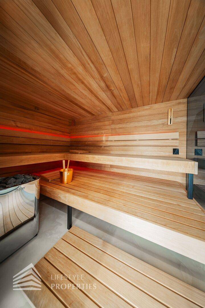 Moderne Holzsauna mit bequemen Bänken und integriertem Ofen für entspannende Momente.