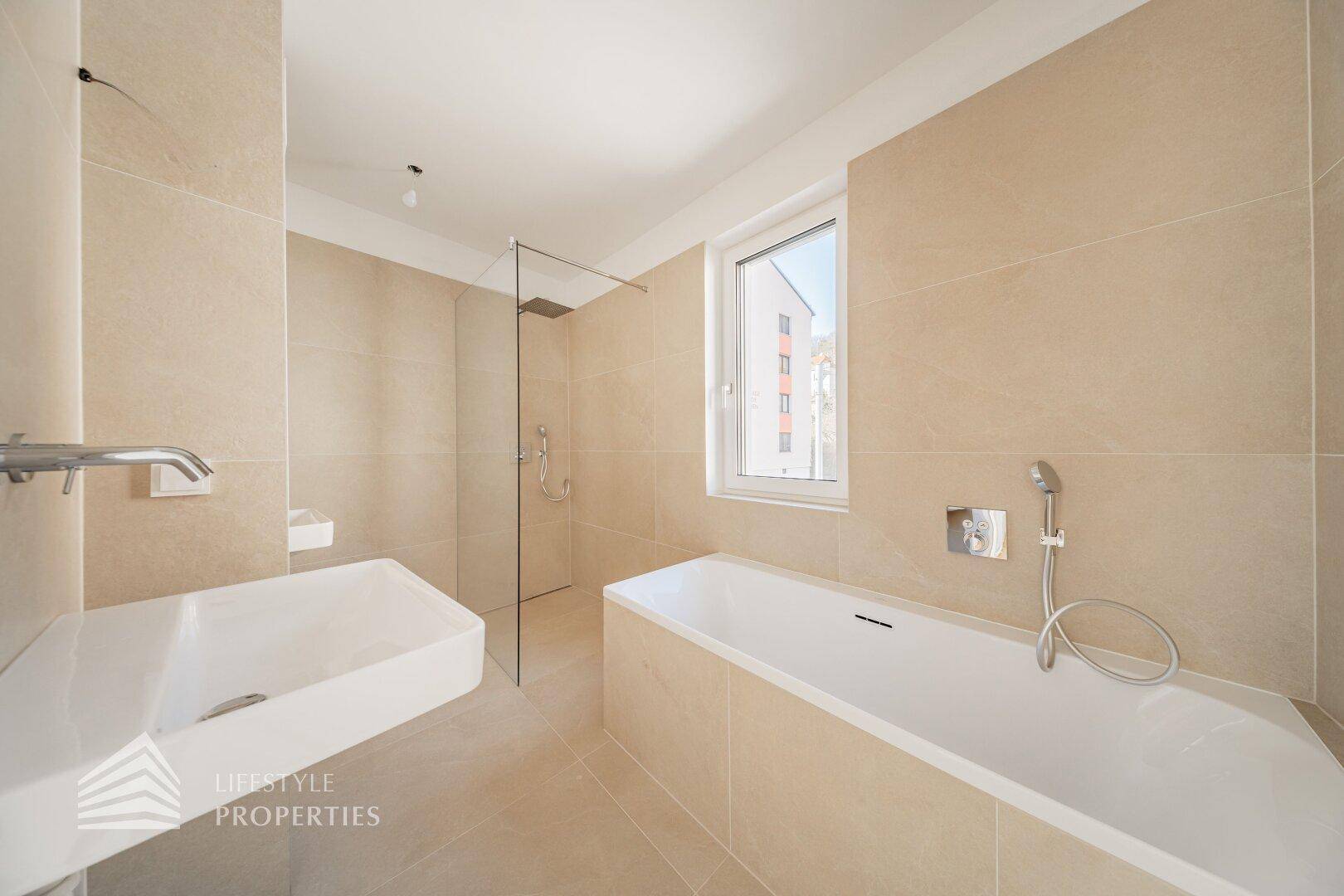 Modernes Badezimmer mit beigefarbenen Fliesen, Badewanne und ebenerdiger Dusche.