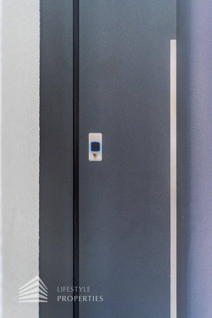 Moderne dunkelgraue Eingangstür mit integriertem digitalen Schließsystem für erhöhte Sicherheit.
