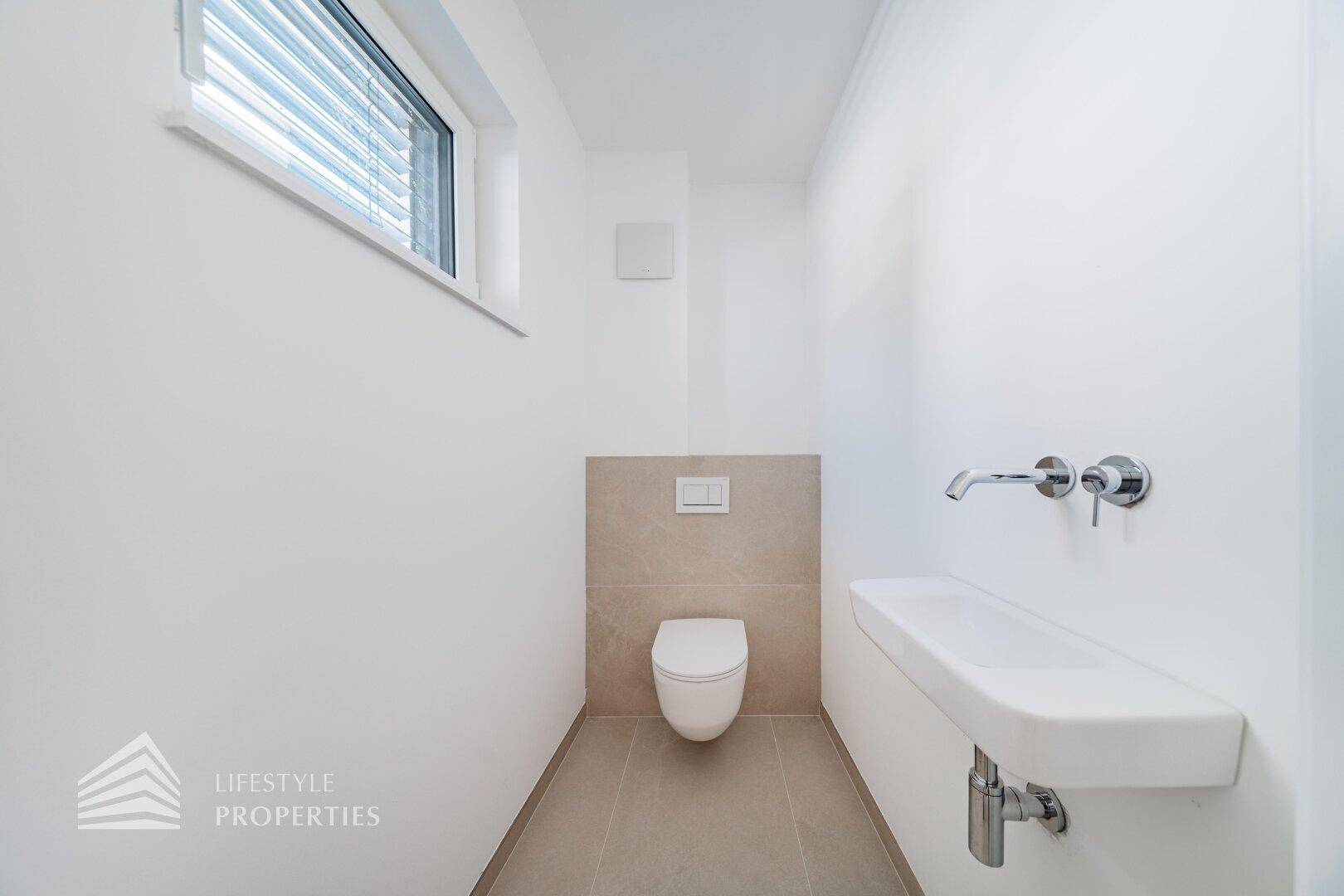 Modernes Gäste-WC mit wandhängender Toilette, schwebendem Waschbecken und kleinem Fenster.