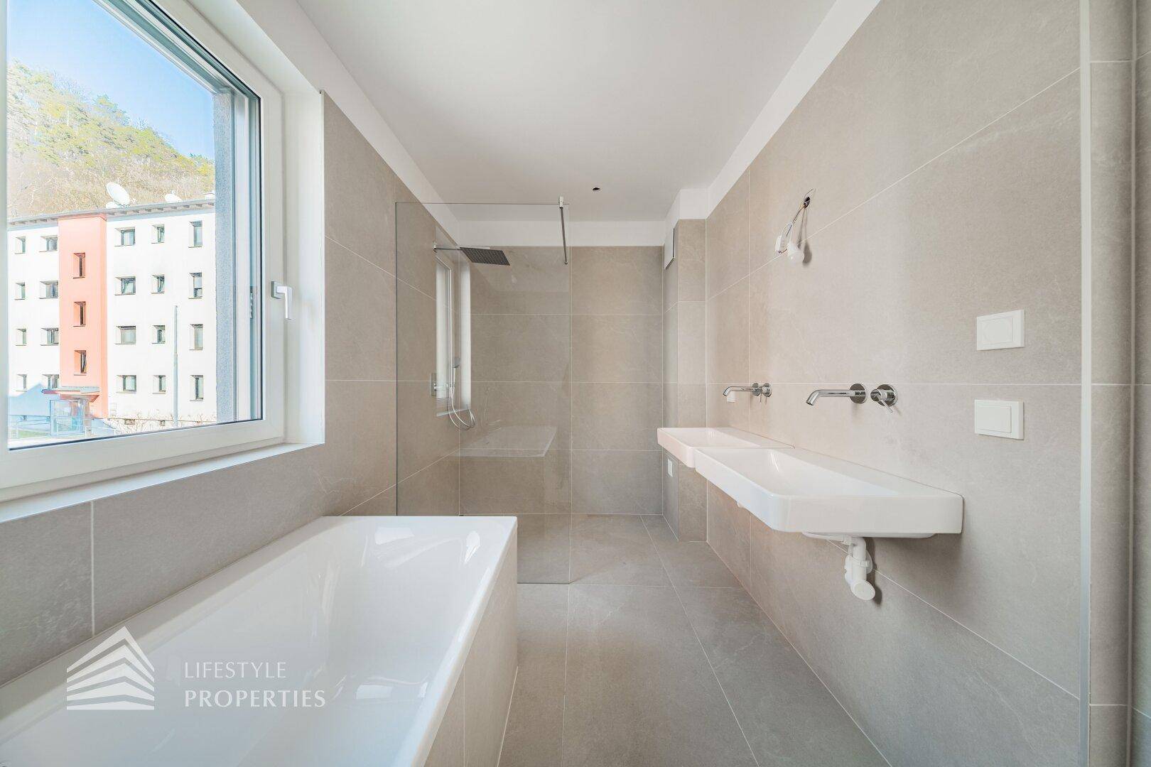 Modernes Badezimmer mit großer Badewanne, begehbarer Dusche und Doppelwaschbecken.