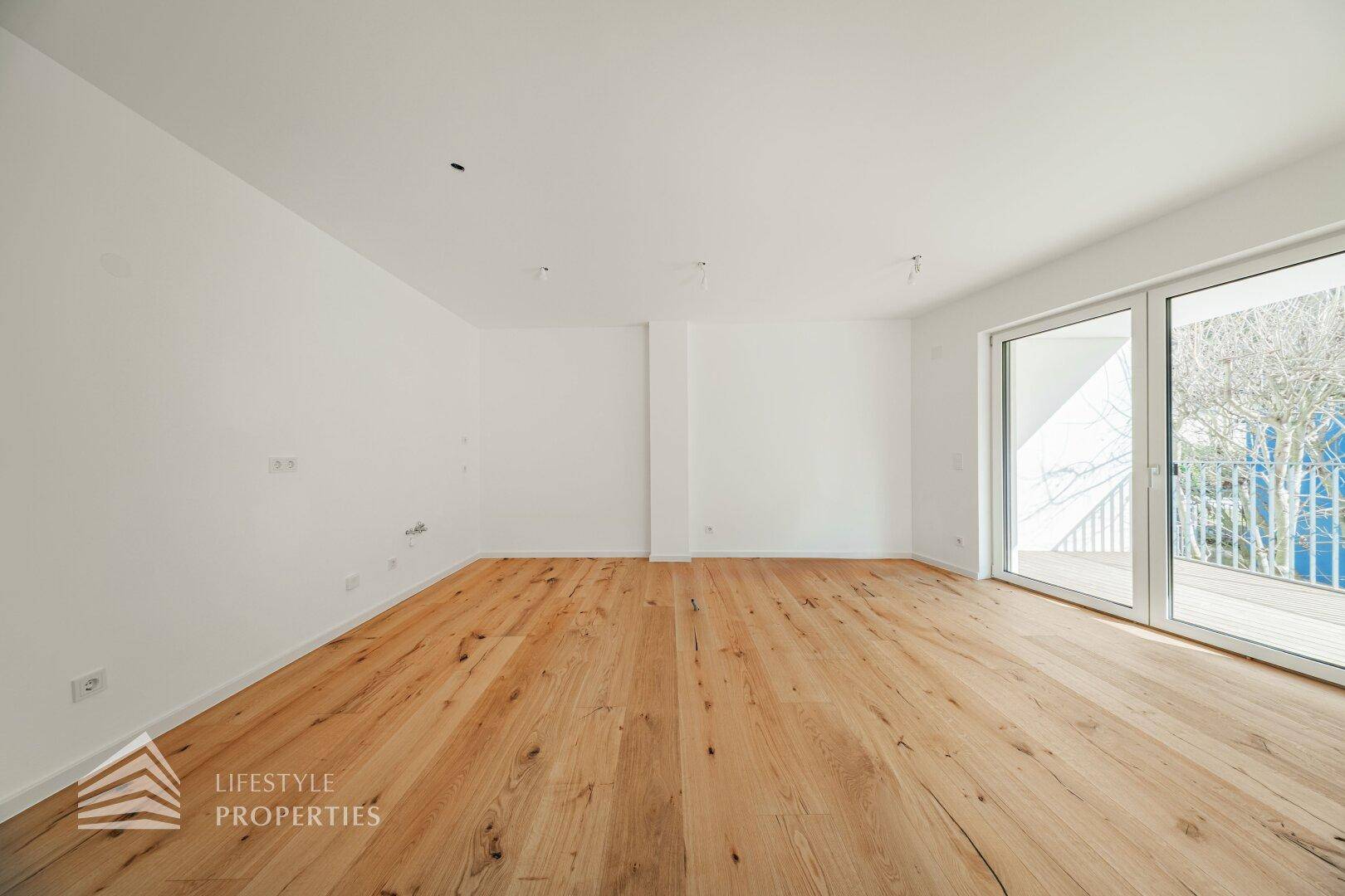 Helles Wohnzimmer mit großen Fenstern und Holzboden, bietet viel Platz und natürliches Licht.