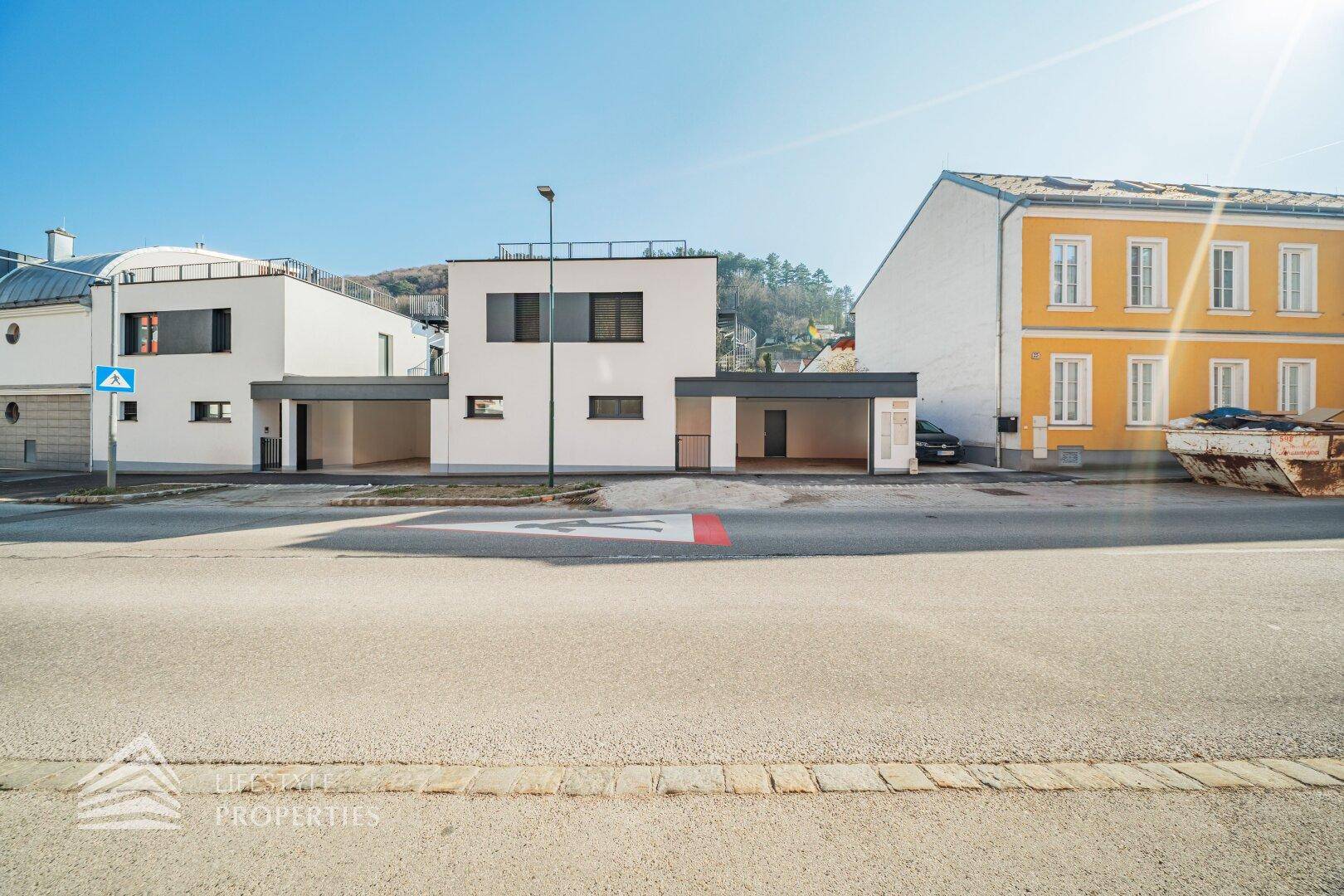 Ansicht von zwei modernen Neubauten mit klaren Linien und integrierten Carports.
