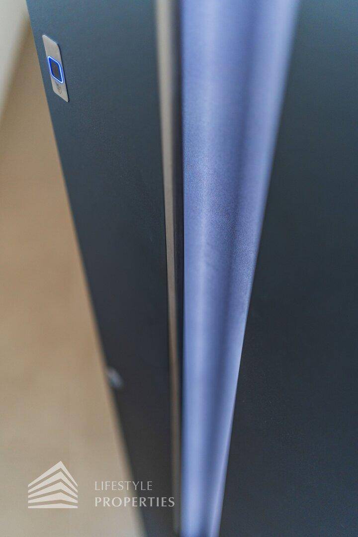 Detailansicht einer modernen Tür mit vertikaler Beleuchtung und Smart-Lock-Funktion.