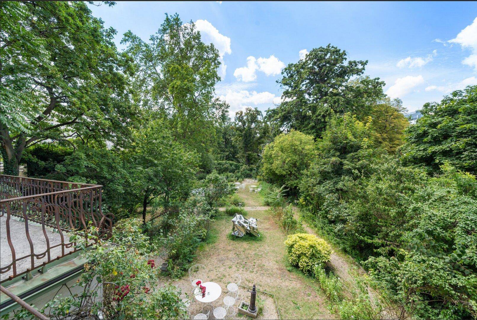 Blick vom Balkon auf den weitläufigen, grünen Garten der Villa.