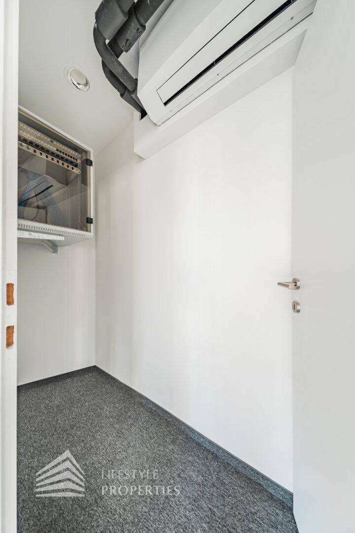 Kleiner Technikraum mit Klimaanlage und Serverschrank, ideal für IT-Infrastruktur.