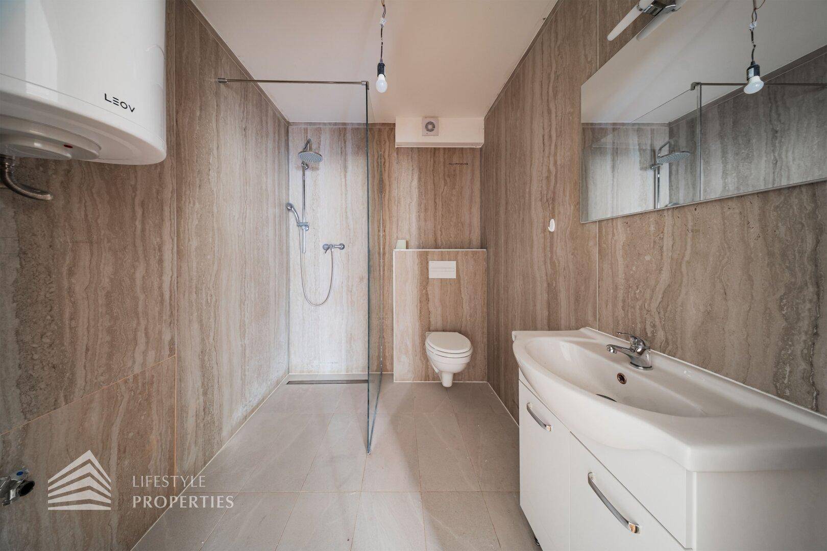 Modernes Badezimmer mit begehbarer Dusche, Wand-WC und großformatigen Fliesen.