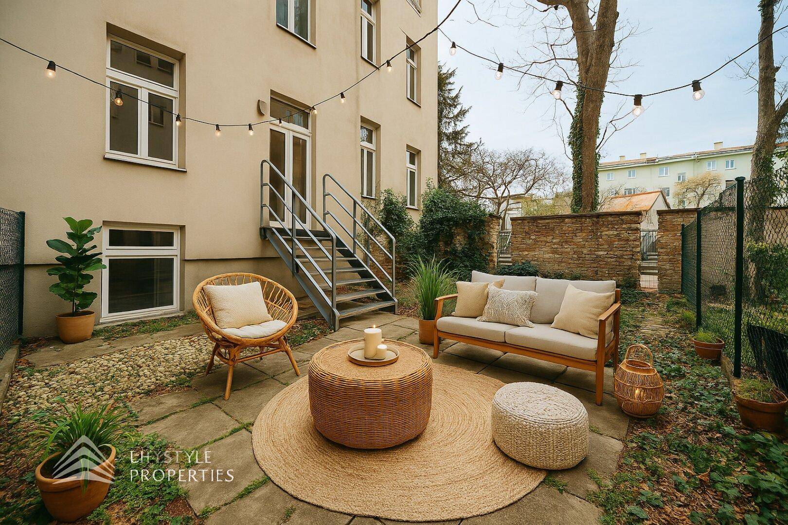 Kleiner, gemütlicher Gartenbereich mit Sitzgelegenheiten und Lichterkette, ideal für entspannte Stunden im Freien.